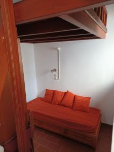 帕特莫斯Σπιτι Χωρα Πατμου的一张床位,房间配有两个橙色枕头
