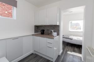 威灵堡20 Leys Road rooms 1 - 4的一间带白色橱柜和床的厨房