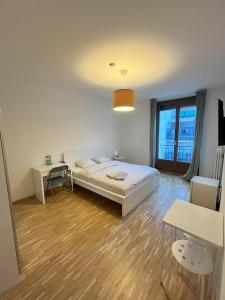 日内瓦Residence Geneva Quartier de Plainpalais的一间卧室配有一张床、一张桌子和一个窗户。