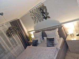 多特蒙德schlafgut24的一间卧室配有带白色床单和枕头的床。
