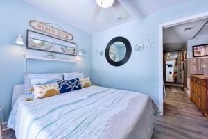 杰克逊维尔海滩Dog-Friendly Jacksonville Beach Apt near Beach的一间蓝色卧室,配有一张床和镜子