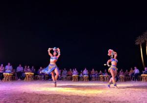 赫尔格达Davinci Beach Hotel的两个女人在舞台上和人群一起表演舞蹈