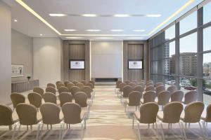 多哈多哈老城希尔顿逸林酒店的一间会议室,配有椅子和白板