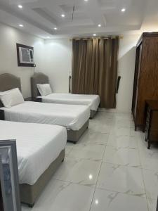 麦地那العمري للشقق المفروشة الشهرية的酒店客房设有两张床和电视。