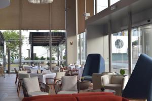 特鲁希略Doubletree By Hilton Trujillo的餐厅设有桌椅和墙上的时钟