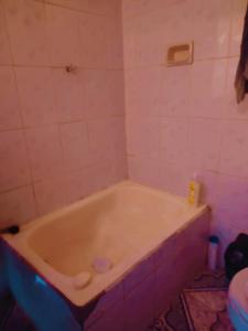 拉巴斯Casa familiar orange corner的浴室设有浴缸,铺有粉红色的瓷砖。