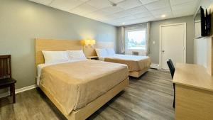 萨默赛德SUMMERSIDE MOTEL &COTTAGES的酒店客房配有两张床和一张书桌