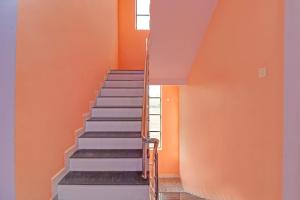 那格浦尔OYO Flagship Hotel Anand In的楼梯,有橙色的墙壁和楼梯间