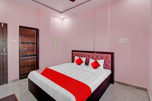 那格浦尔OYO Flagship Hotel Anand In的一间卧室配有一张带红色枕头的大床