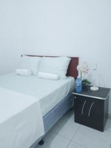 拉乌尼翁Acogedora casa en Lomas de Bella Vista的一间卧室配有一张床,床头柜配有一张白色的床