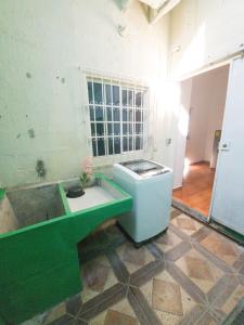 拉乌尼翁Acogedora casa en Lomas de Bella Vista的浴室配有绿色水槽和浴缸。