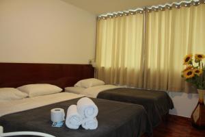 利马COPACABANA的两张位于酒店客房的床 - 带毛巾