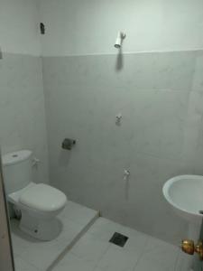 亭可马里Udayam guest的白色的浴室设有卫生间和水槽。