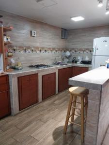 基多Hostal Benalcazar的厨房配有木制橱柜和白色冰箱。