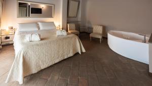 菲亚诺Relais Bella Rosina Pool & Spa的一间卧室配有一张床和浴缸