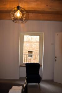 乌尔比诺Bramante Suites Urbino的一间带椅子和窗户的房间