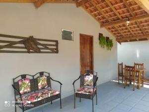 林多亚Pousada irmãos Oliveira的一间设有两把椅子和一张桌子的房间,以及木制天花板