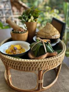 卡塔海滩Greenheart garden View Camp phuket的一张柳条桌子,上面有一盘食物