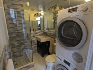 纽约Room at the Heart of East Village的带卫生间的浴室内的洗衣机和烘干机
