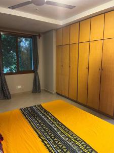 达累斯萨拉姆Zanzibar in Dar! A newly renovated 3br villa的一间卧室配有一张黄色的床和木制橱柜。