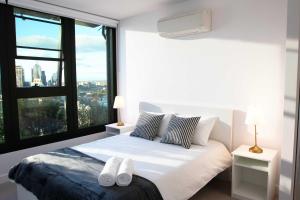 墨尔本Pars apartments - Melbourne Quarter- unique View of city and Yarra的一间卧室配有一张带两条白色毛巾的床