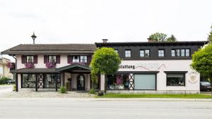 基姆湖畔贝尔瑙Gästehaus Sattlerhof的街道边的粉红色和白色建筑
