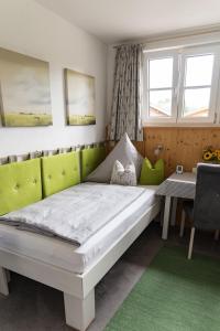 基姆湖畔贝尔瑙Gästehaus Sattlerhof的卧室配有床、桌子和窗户。