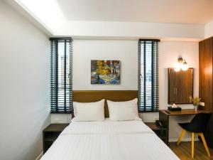 占那县Kitzio House Hotel Huai Kwang的卧室配有一张白色大床和一张书桌