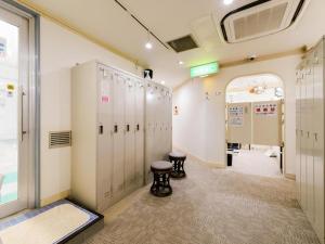 东京Itabashi Hotel Hilltop的更衣室设有储物柜和凳子