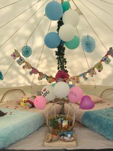 新加坡Glamping kaki singapore-Standard medium bell tent的一间房间,床上放着一大堆气球