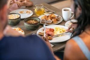 玛志洛Holiday Inn Express & Suites Sunshine Coast, an IHG Hotel的一群坐在桌子上吃早饭的人