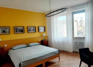 曼托瓦Foresteria Juvarra的一间卧室设有一张床和黄色的墙壁