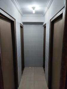 珀尼达岛Ega S Hostel的走廊设有两扇门,铺有瓷砖地板