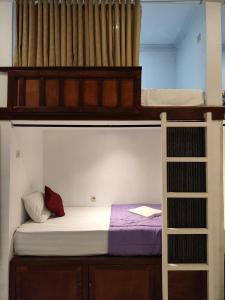 珀尼达岛Ega S Hostel的一间卧室设有两张双层床和梯子