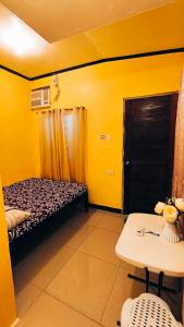 莫阿尔博阿CheRi Backpackers Hostel的黄色的房间,配有床和桌子
