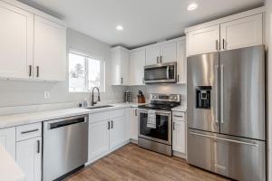 西雅图Beautifully remodeled Rambler in South Seattle的厨房配有白色橱柜和不锈钢用具