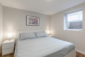西雅图Beautifully remodeled Rambler in South Seattle的一间白色卧室,配有床和2个床头柜