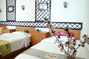 拉萨格桑花香香氛酒店的酒店客房带两张床和一个花瓶