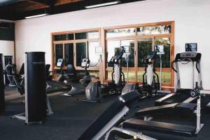 拉罗马纳Modern Condo in Casa de Campo的健身房,设有数排跑步机和椭圆机
