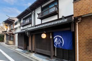 京都Rinn Shijo Machiya的上面有蓝白色标志的建筑