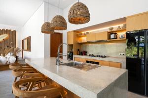 乌布Villa Donna by BaliSuperHost的厨房配有水槽和带椅子的柜台。
