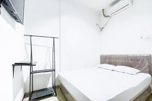 贝克西Citara Jaya Guesthouse Mitra RedDoorz的白色的客房配有床和镜子
