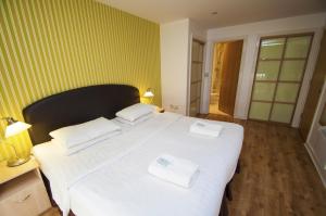 爱丁堡Ocean Serviced Apartments的一间卧室配有一张大床和两条毛巾