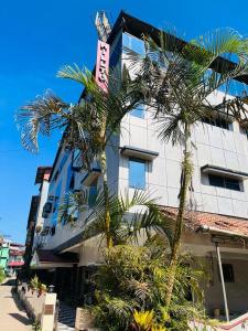 马迪凯里Coorg HillTown Hotel - Madikeri的一座棕榈树建筑
