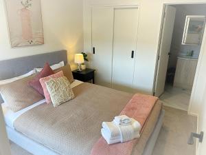 奥克兰布什假期住宿公寓的一间卧室配有一张床,上面有两条毛巾