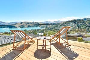 阿卡罗阿Akaroa Harbour View - Christchurch Holiday Homes的观景甲板上配有两把椅子和一张桌子