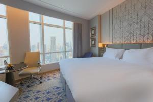 曼谷Centara Grand At CentralWorld的酒店客房设有一张大床和窗户。