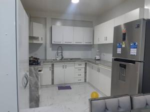 伊察Casa Piscina Duna Saraja Ica-Perú的厨房配有白色橱柜和冰箱。