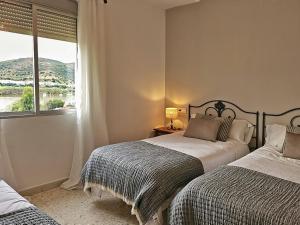 瓜迪亚纳河畔桑卢卡尔洛斯毛利诺斯酒店的一间卧室设有两张床和窗户。