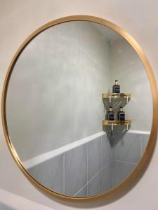 BasbasClarity’s Staycation的一面墙面上带两个架子的圆镜子